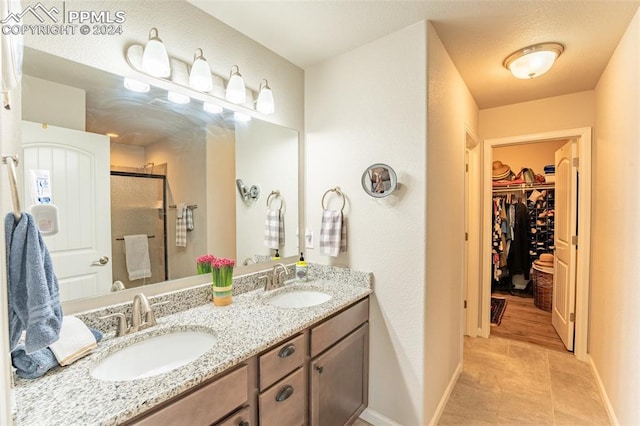 bathroom with vanity, tile patterned floors, and a shower with door