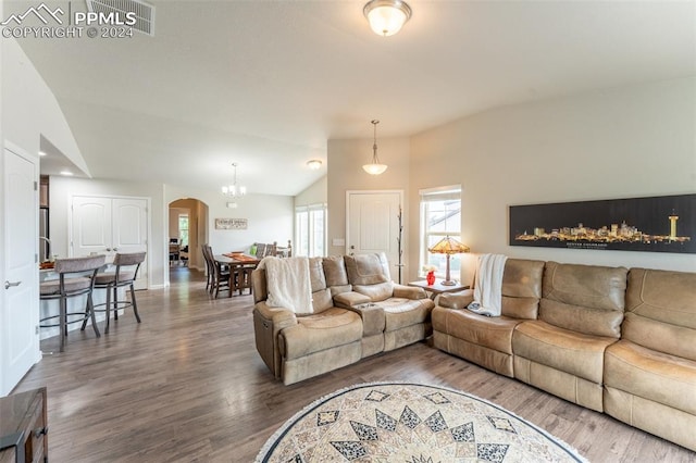 living room with vaulted ceiling, a chandelier, and hardwood / wood-style flooring