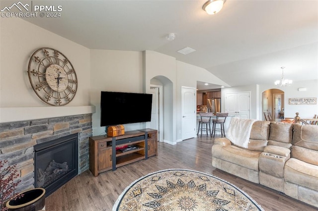 living room with a fireplace, lofted ceiling, wood-type flooring, and a chandelier