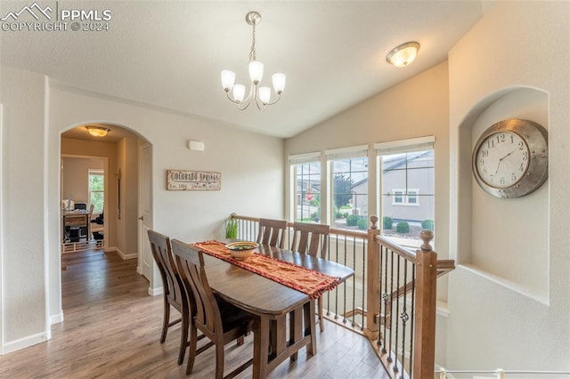 dining area with lofted ceiling, hardwood / wood-style floors, a chandelier, and a healthy amount of sunlight