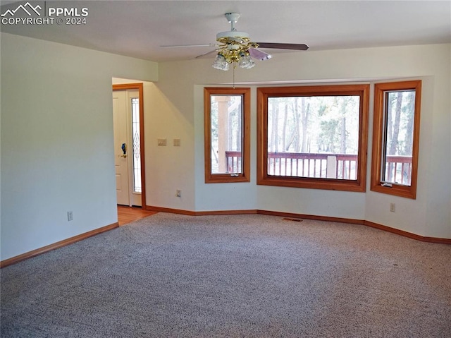 carpeted spare room featuring ceiling fan