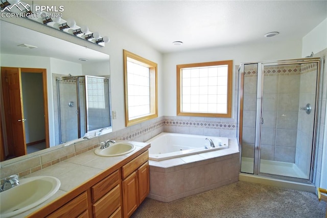 bathroom with vanity and shower with separate bathtub