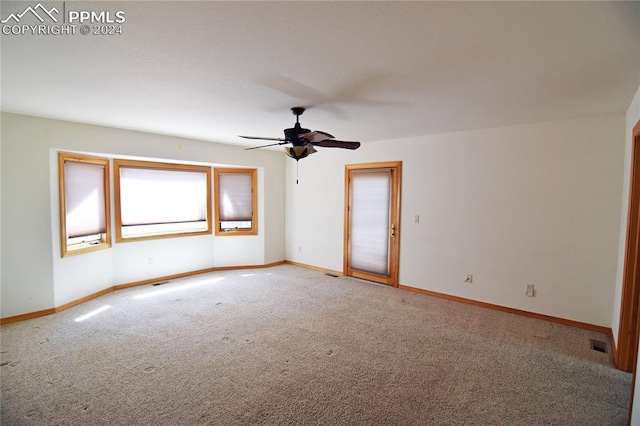 empty room with ceiling fan and carpet flooring