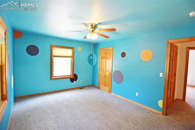 carpeted empty room featuring ceiling fan