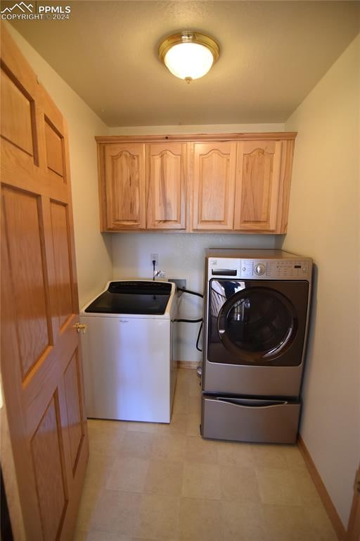 laundry room with cabinets and washing machine and dryer