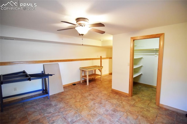 interior space featuring ceiling fan, a walk in closet, and a closet