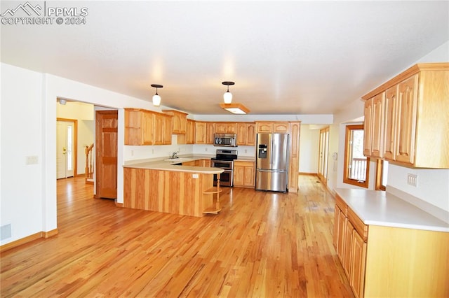 kitchen with light wood-type flooring, stainless steel appliances, light brown cabinetry, kitchen peninsula, and sink