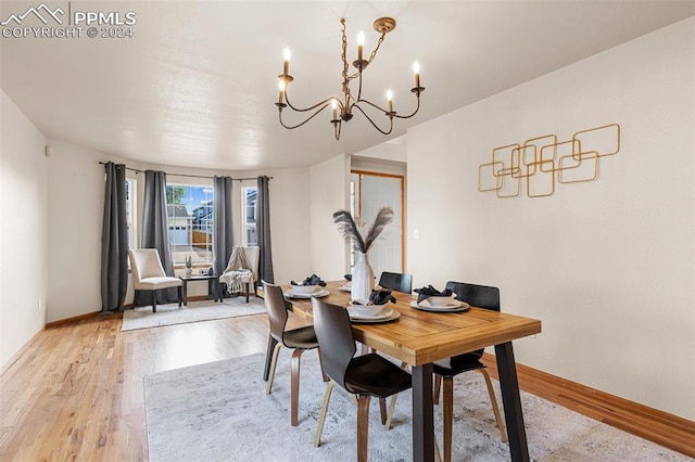 dining space with an inviting chandelier and light hardwood / wood-style flooring