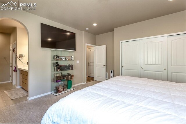 bedroom featuring a closet, carpet floors, and ensuite bathroom