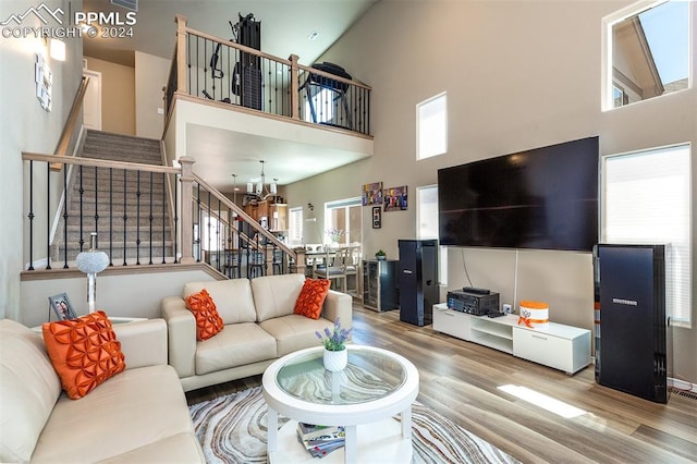 living room with hardwood / wood-style flooring, high vaulted ceiling, and a wealth of natural light