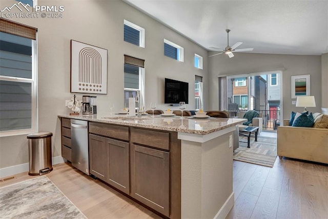 kitchen with dishwasher, light stone counters, light hardwood / wood-style floors, sink, and ceiling fan