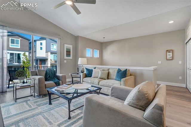 living room featuring a healthy amount of sunlight, ceiling fan, vaulted ceiling, and light hardwood / wood-style floors