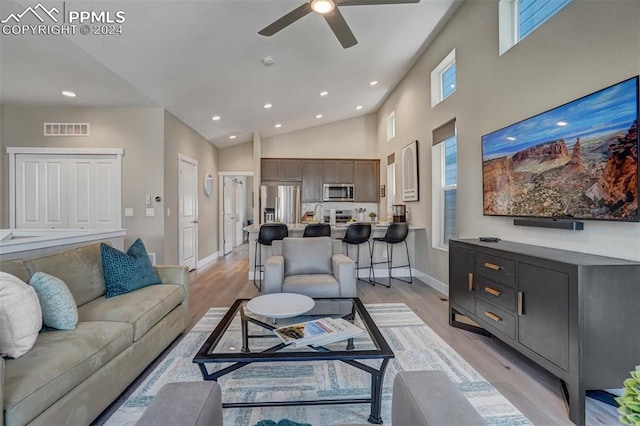 living room featuring high vaulted ceiling, ceiling fan, and light hardwood / wood-style floors