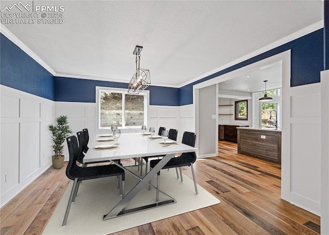 dining space with crown molding, light hardwood / wood-style flooring, and a healthy amount of sunlight