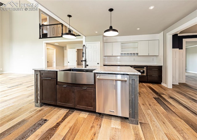 kitchen featuring light hardwood / wood-style floors, sink, hanging light fixtures, appliances with stainless steel finishes, and white cabinetry