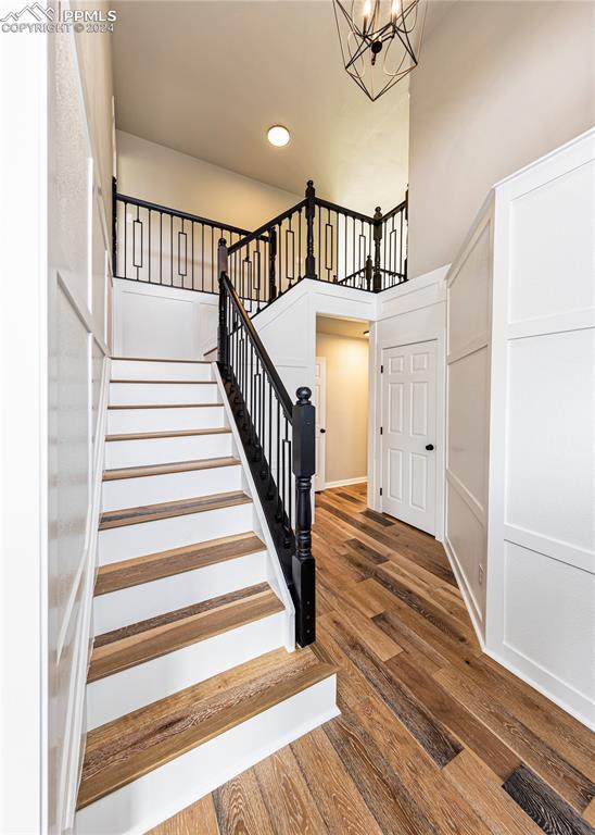 stairs with a notable chandelier and hardwood / wood-style floors