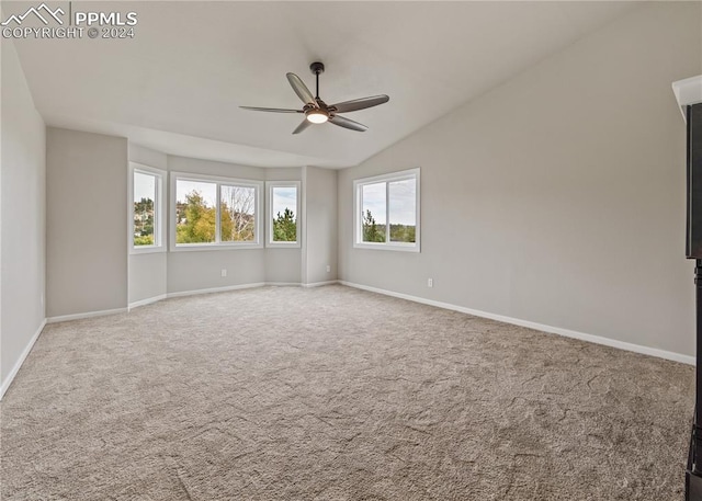 carpeted spare room featuring vaulted ceiling and ceiling fan