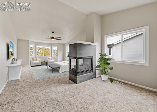 carpeted bedroom featuring ceiling fan, a multi sided fireplace, and lofted ceiling