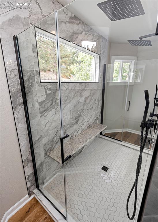 bathroom with a shower with door and wood-type flooring