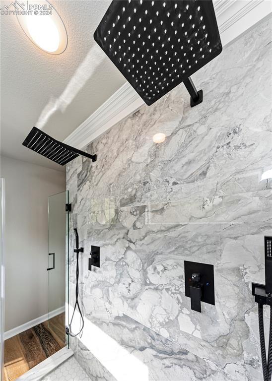 room details with walk in shower, crown molding, hardwood / wood-style floors, and a textured ceiling