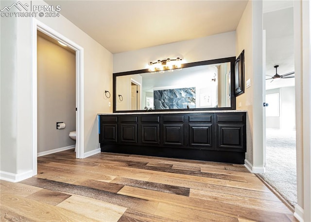 bathroom featuring ceiling fan, vanity, toilet, and wood-type flooring