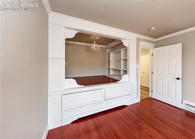 unfurnished bedroom with a notable chandelier, a closet, dark hardwood / wood-style floors, and crown molding