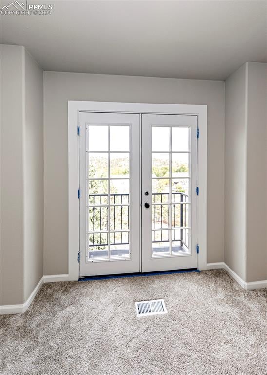 doorway to outside featuring french doors and light colored carpet