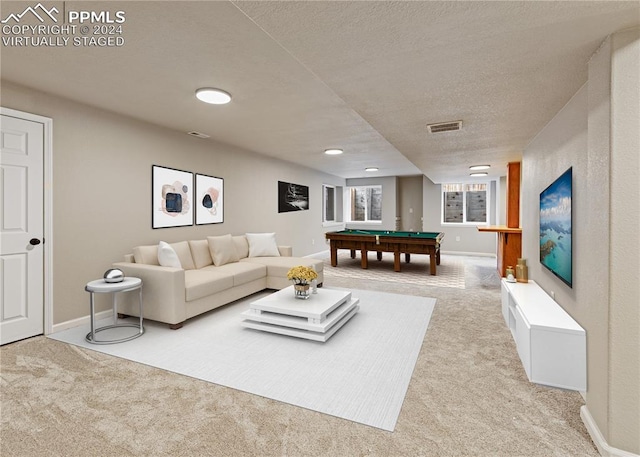 carpeted living room with billiards and a textured ceiling