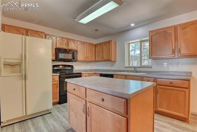 kitchen featuring black appliances, a center island, light hardwood / wood-style floors, and sink