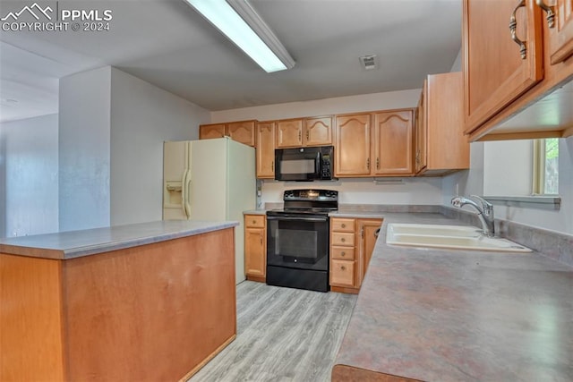 kitchen featuring black appliances, sink, and light hardwood / wood-style flooring