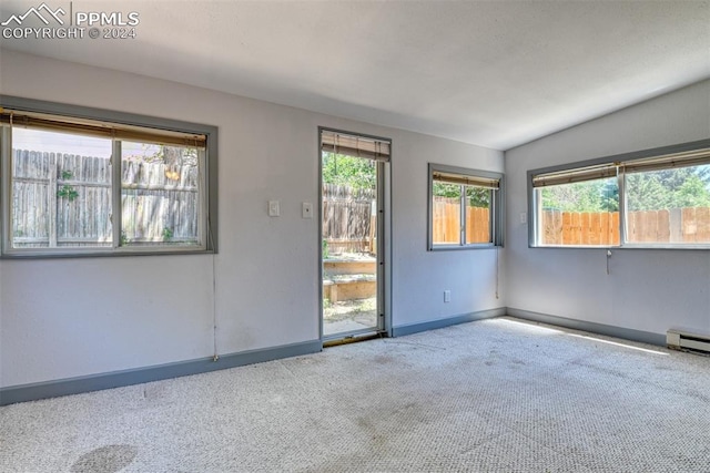 carpeted empty room featuring lofted ceiling and a baseboard radiator