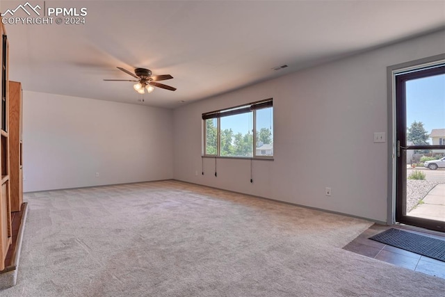 empty room with ceiling fan and light carpet