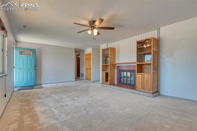 unfurnished living room featuring carpet flooring, ceiling fan, and a fireplace