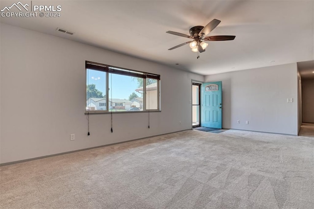 spare room with ceiling fan and light carpet