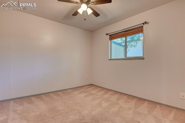 spare room with ceiling fan and light carpet