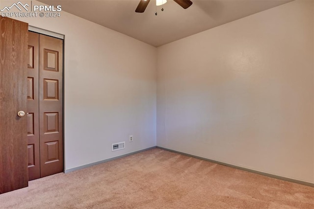 unfurnished room with ceiling fan and light colored carpet