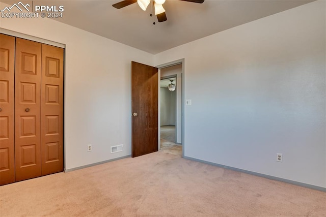 unfurnished bedroom with ceiling fan, carpet floors, and a closet