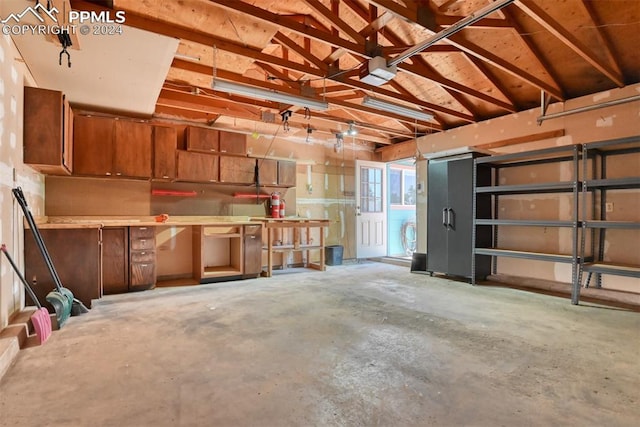 garage with a workshop area and a garage door opener