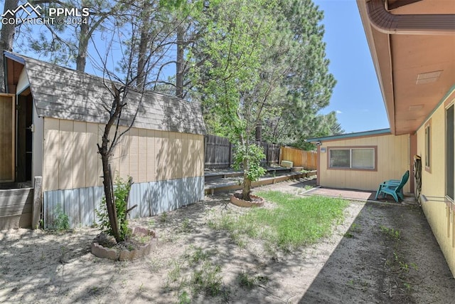 view of yard featuring a patio area and a storage shed