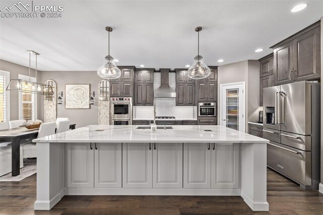 kitchen with dark hardwood / wood-style flooring, an island with sink, white cabinetry, stainless steel dishwasher, and sink