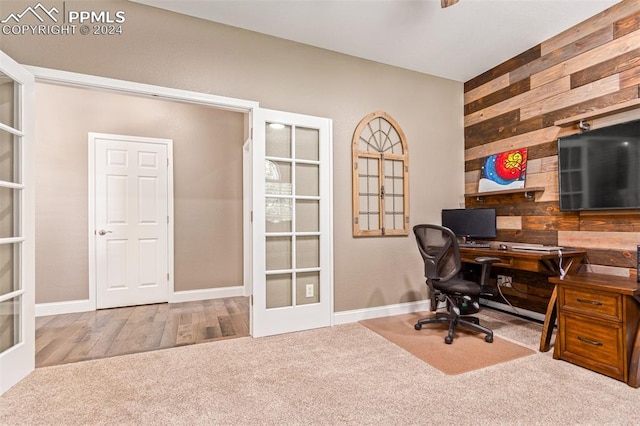 home office featuring french doors, wooden walls, and hardwood / wood-style floors