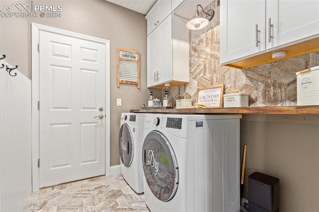 washroom featuring washer and dryer and cabinets