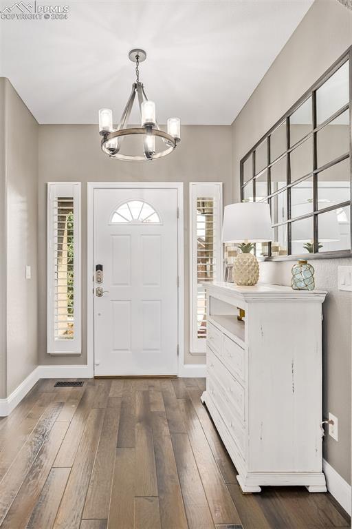 entryway with a notable chandelier and hardwood / wood-style flooring