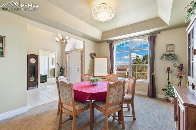 dining room with light colored carpet, an inviting chandelier, and a tray ceiling