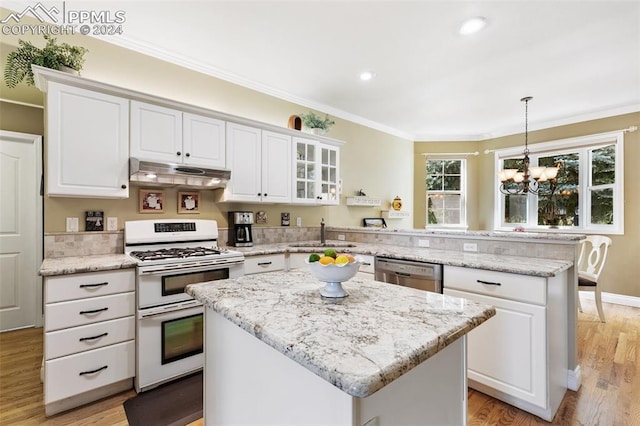 kitchen featuring pendant lighting, a center island, white gas stove, and an inviting chandelier