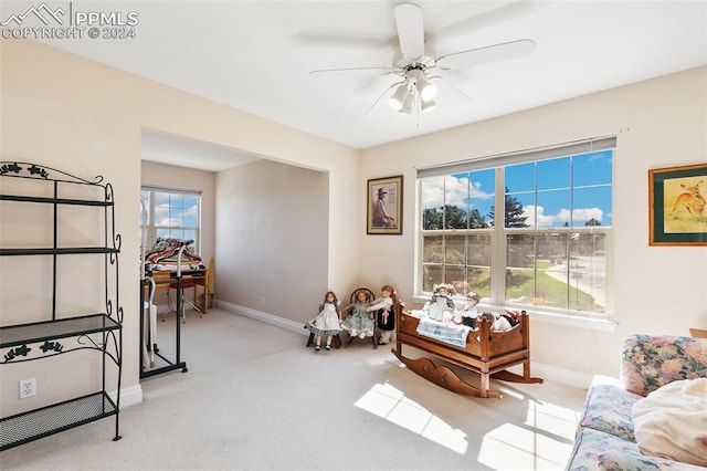 interior space with ceiling fan and light colored carpet