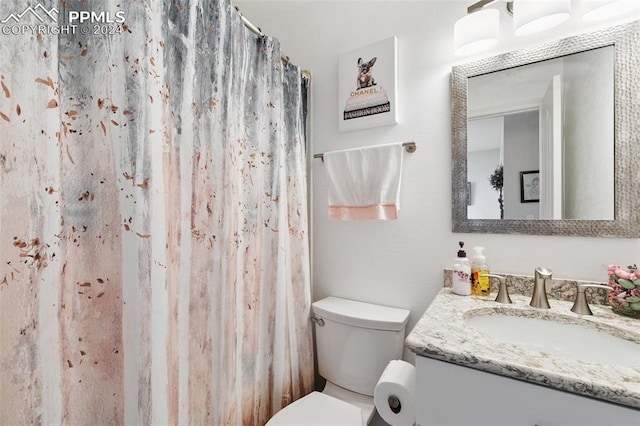 bathroom with a shower with shower curtain, vanity, and toilet