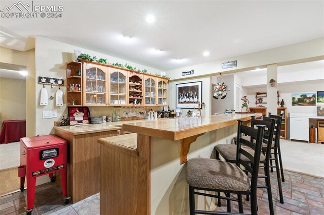 kitchen featuring a kitchen bar and kitchen peninsula