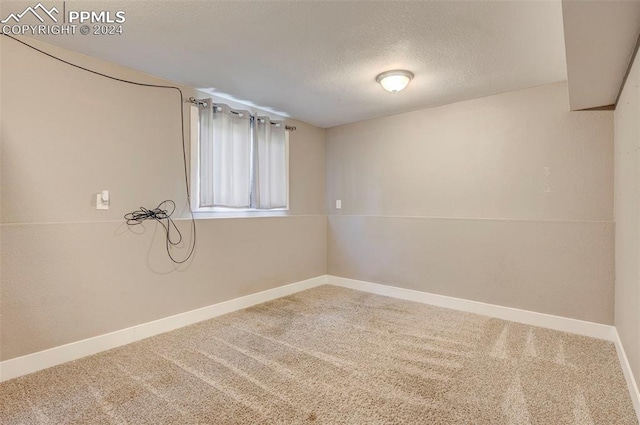 empty room with carpet floors and a textured ceiling