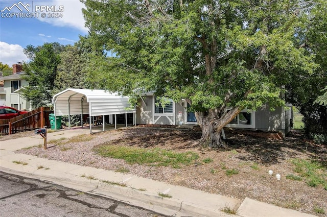 view of property hidden behind natural elements featuring a carport